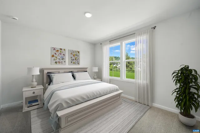 a bedroom with a large bed and a potted plant