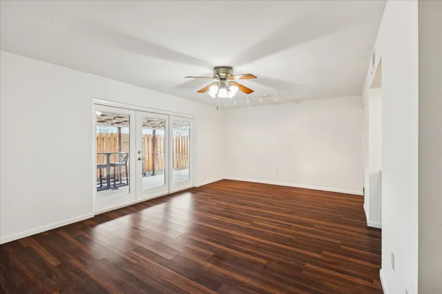 a view of an empty room with window and a ceiling fan