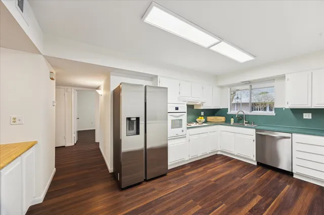 a kitchen with stainless steel appliances a refrigerator and a stove top oven
