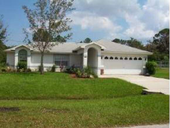 1363 Southeast Ruffin Palm Bay, FL 32909 - Photo 1 of 1 a front view of a house with a garden