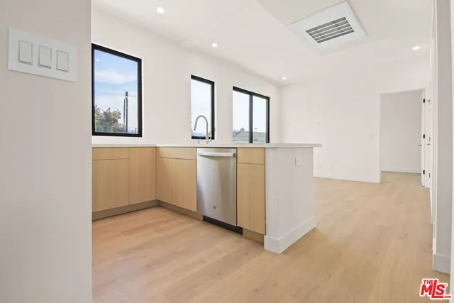 a view of kitchen with wooden floor and electronic appliances