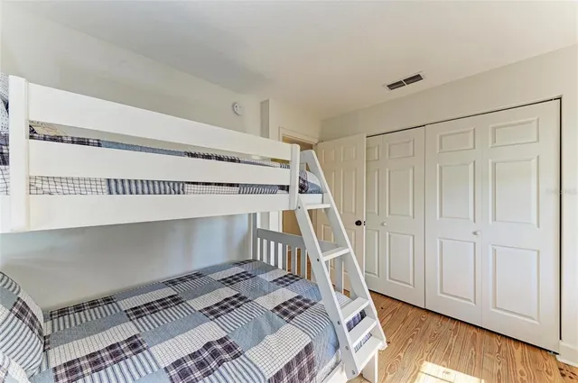 a view of a bedroom with wooden floor and stairs