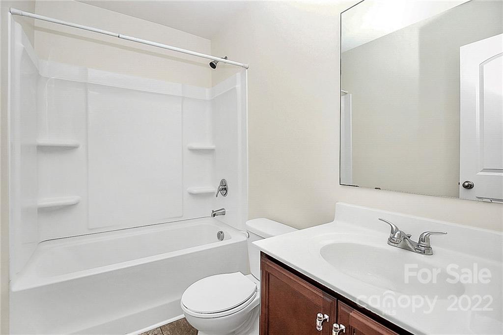 8729 Pence Road Charlotte, NC 28215 - Photo 17 of 26 a bathroom with a granite countertop sink a toilet and shower