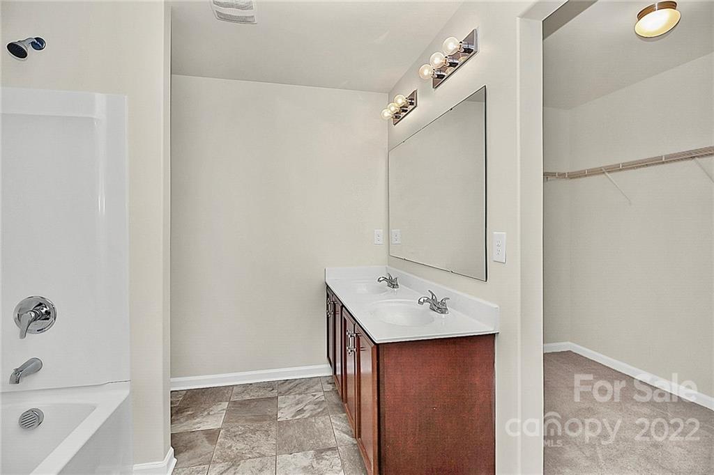 8729 Pence Road Charlotte, NC 28215 - Photo 22 of 26 a bathroom with a tub sink and mirror