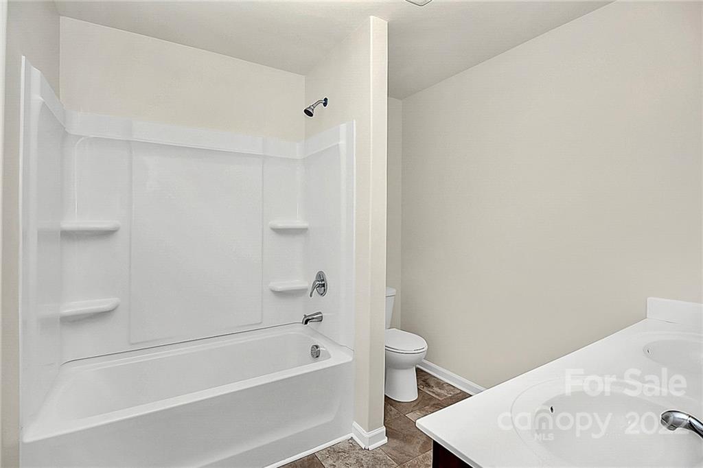8729 Pence Road Charlotte, NC 28215 - Photo 23 of 26 a bathroom with a bathtub and toilet