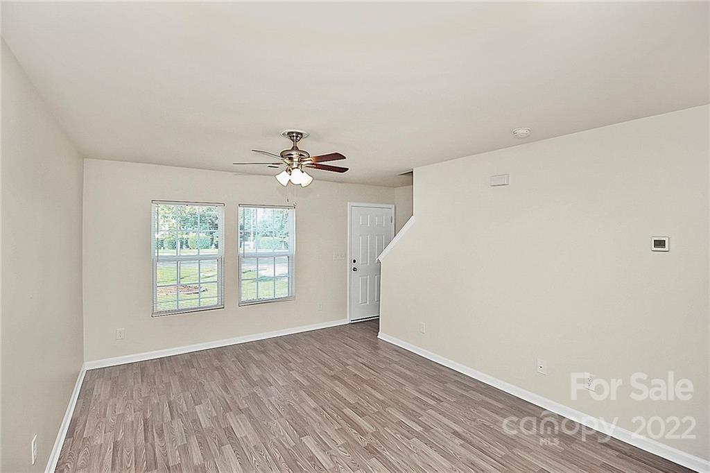 8729 Pence Road Charlotte, NC 28215 - Photo 5 of 26 a view of an empty room with wooden floor and a window