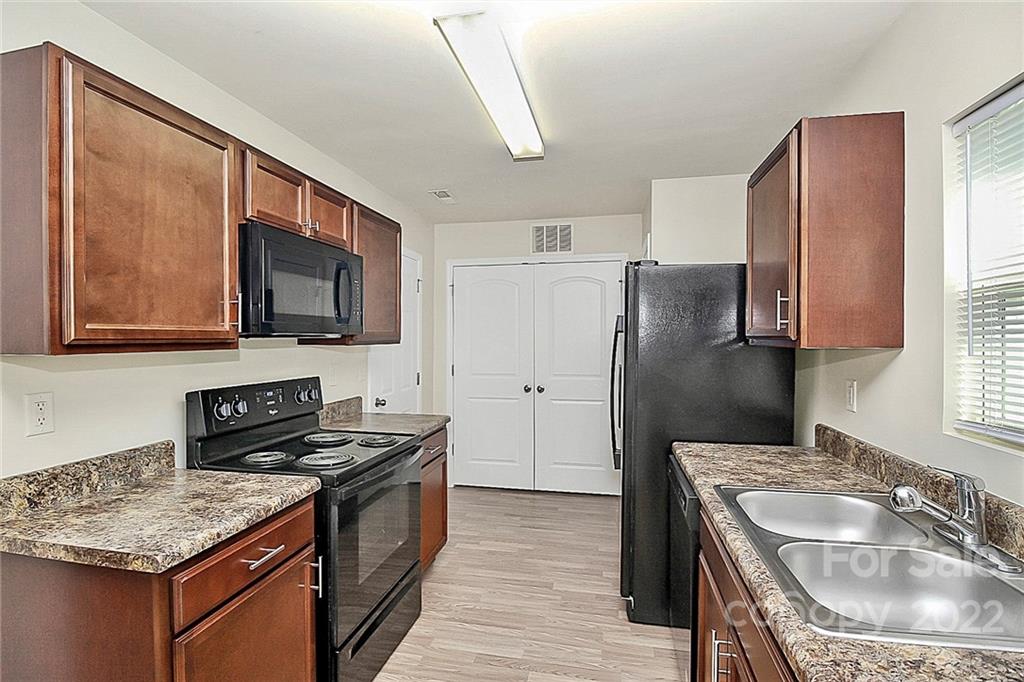 8729 Pence Road Charlotte, NC 28215 - Photo 10 of 26 a kitchen with stainless steel appliances granite countertop a sink stove and refrigerator