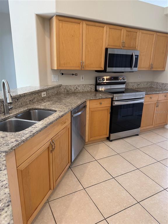 4833 Post Pointe Drive Sarasota, FL 34233 - Photo 11 of 29 a kitchen with granite countertop a sink and a stove top oven