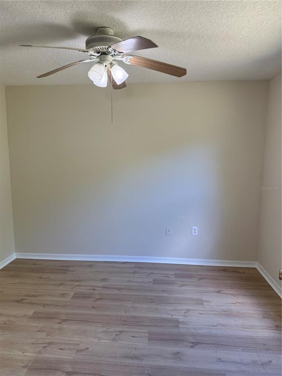 4833 Post Pointe Drive Sarasota, FL 34233 - Photo 18 of 29 a view of a room with wooden floor and white walls