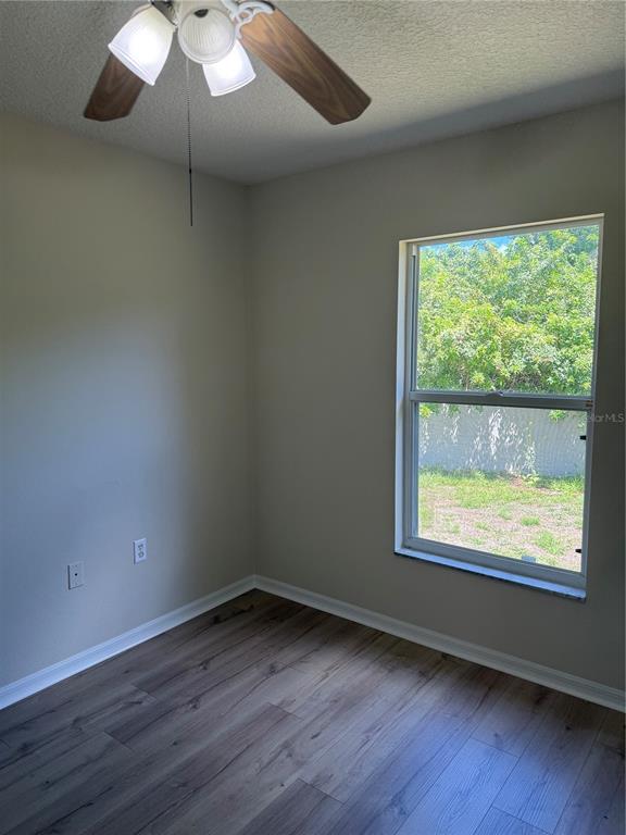 4833 Post Pointe Drive Sarasota, FL 34233 - Photo 19 of 29 an empty room with wooden floor and windows