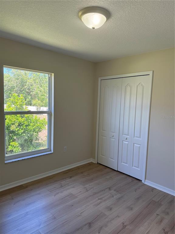 4833 Post Pointe Drive Sarasota, FL 34233 - Photo 24 of 29 a view of an empty room with wooden floor and a window