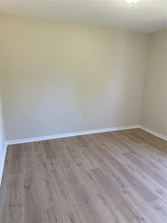 4833 Post Pointe Drive Sarasota, FL 34233 - Photo 26 of 29 a view of an empty room with wooden floor