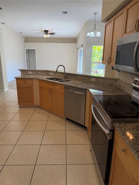 4833 Post Pointe Drive Sarasota, FL 34233 - Photo 7 of 29 a kitchen with granite countertop a sink a stove top oven and cabinets