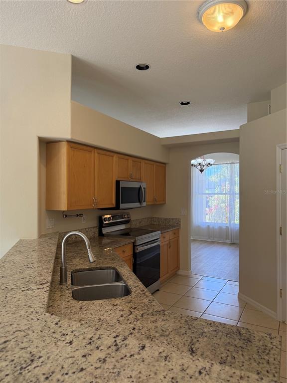 4833 Post Pointe Drive Sarasota, FL 34233 - Photo 9 of 29 a kitchen with stainless steel appliances granite countertop a sink and a stove top oven with granite countertops