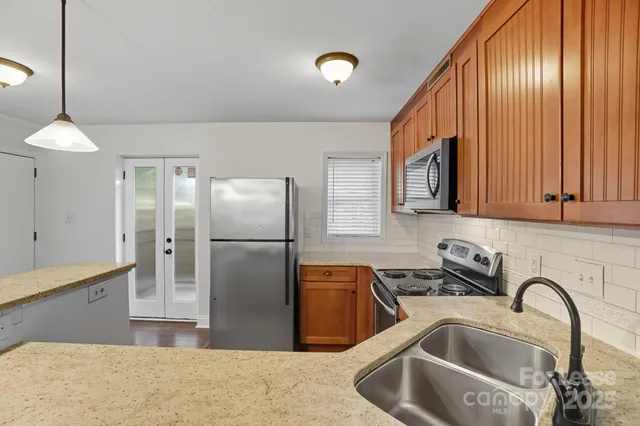 a kitchen with granite countertop a sink and cabinets