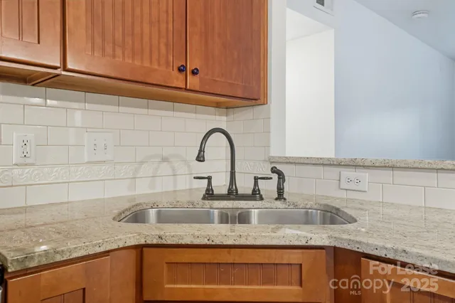 a kitchen with a sink a stove and a wooden floor
