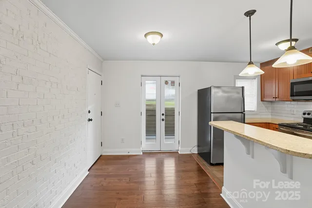 a view of kitchen with wooden floor electronic appliances and window