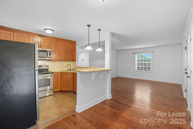 a kitchen with stainless steel appliances granite countertop a refrigerator a stove top oven a sink and dishwasher