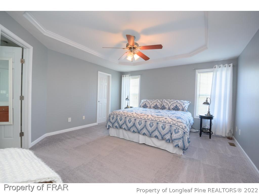 11 Lattimore Road Cameron, NC 28326 - Photo 16 of 28 a bedroom with a bed and a chandelier