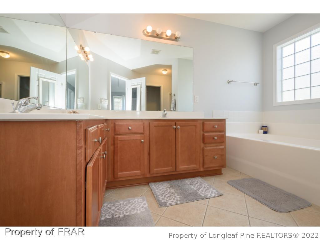 11 Lattimore Road Cameron, NC 28326 - Photo 17 of 28 a bathroom with a sink a mirror and a bathtub