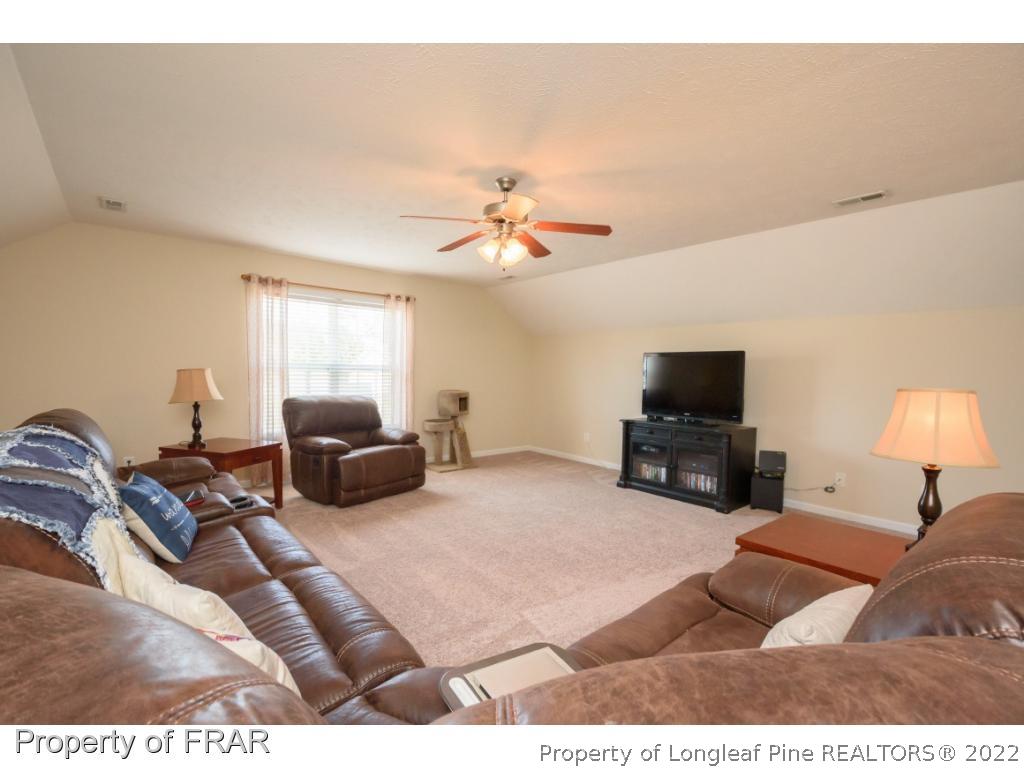 11 Lattimore Road Cameron, NC 28326 - Photo 23 of 28 a living room with furniture a ceiling fan and a flat screen tv