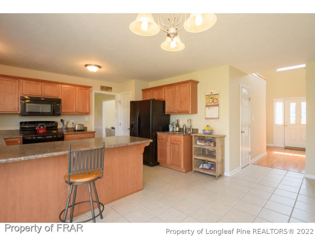11 Lattimore Road Cameron, NC 28326 - Photo 9 of 28 a kitchen with stainless steel appliances a refrigerator and a stove top oven