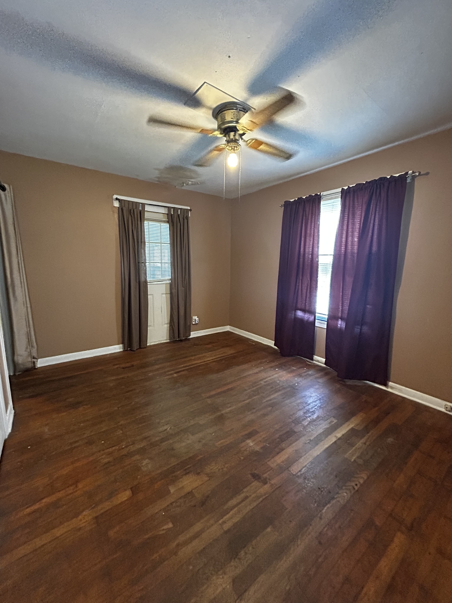 5702 Duval Street Austin, TX 78752 - Photo 20 of 31 Room featuring wood-finish flooring, neutral wall tones, and white baseboards