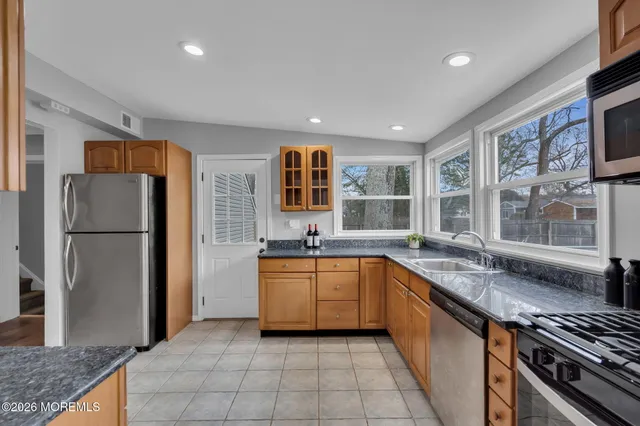 a view of an empty room and chandelier fan