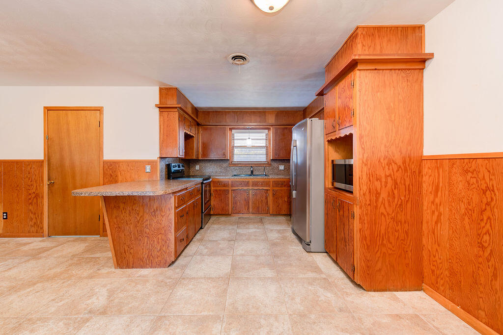 4406 26th Street Lubbock, TX 79410 - Photo 6 of 22 a kitchen with stainless steel appliances a refrigerator and a more cabinets