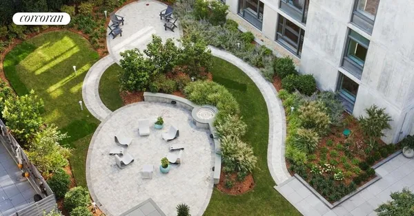 an aerial view of a swimming pool with outdoor seating and yard
