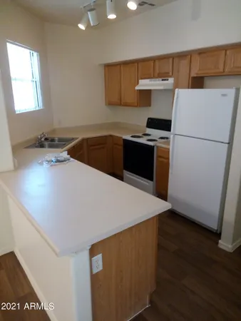 a kitchen with a sink a stove and wooden floor