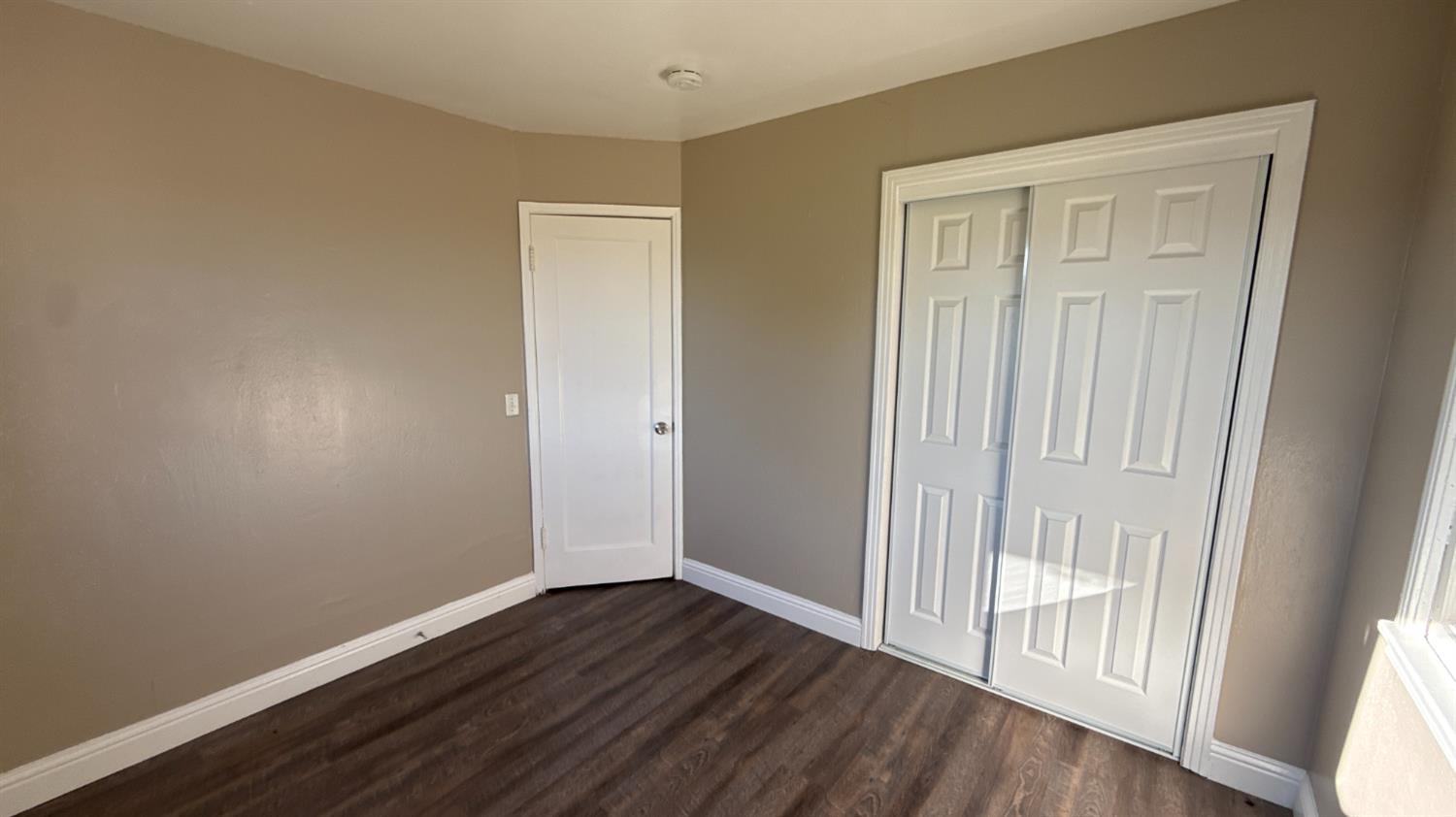 720 East Pleasant Street Coalinga, CA 93210 - Photo 13 of 18 an empty room with wooden floor and windows
