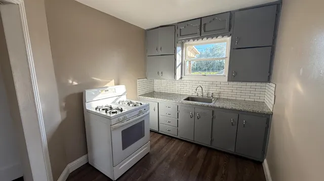 a kitchen with a stove sink and window