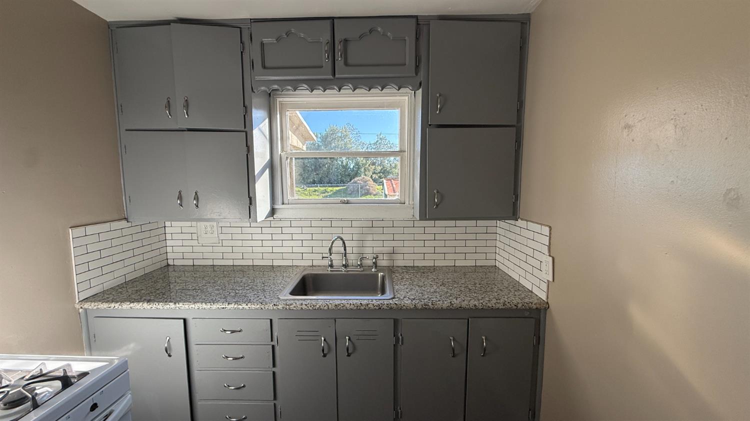 720 East Pleasant Street Coalinga, CA 93210 - Photo 4 of 18 a kitchen with a sink a window and cabinets