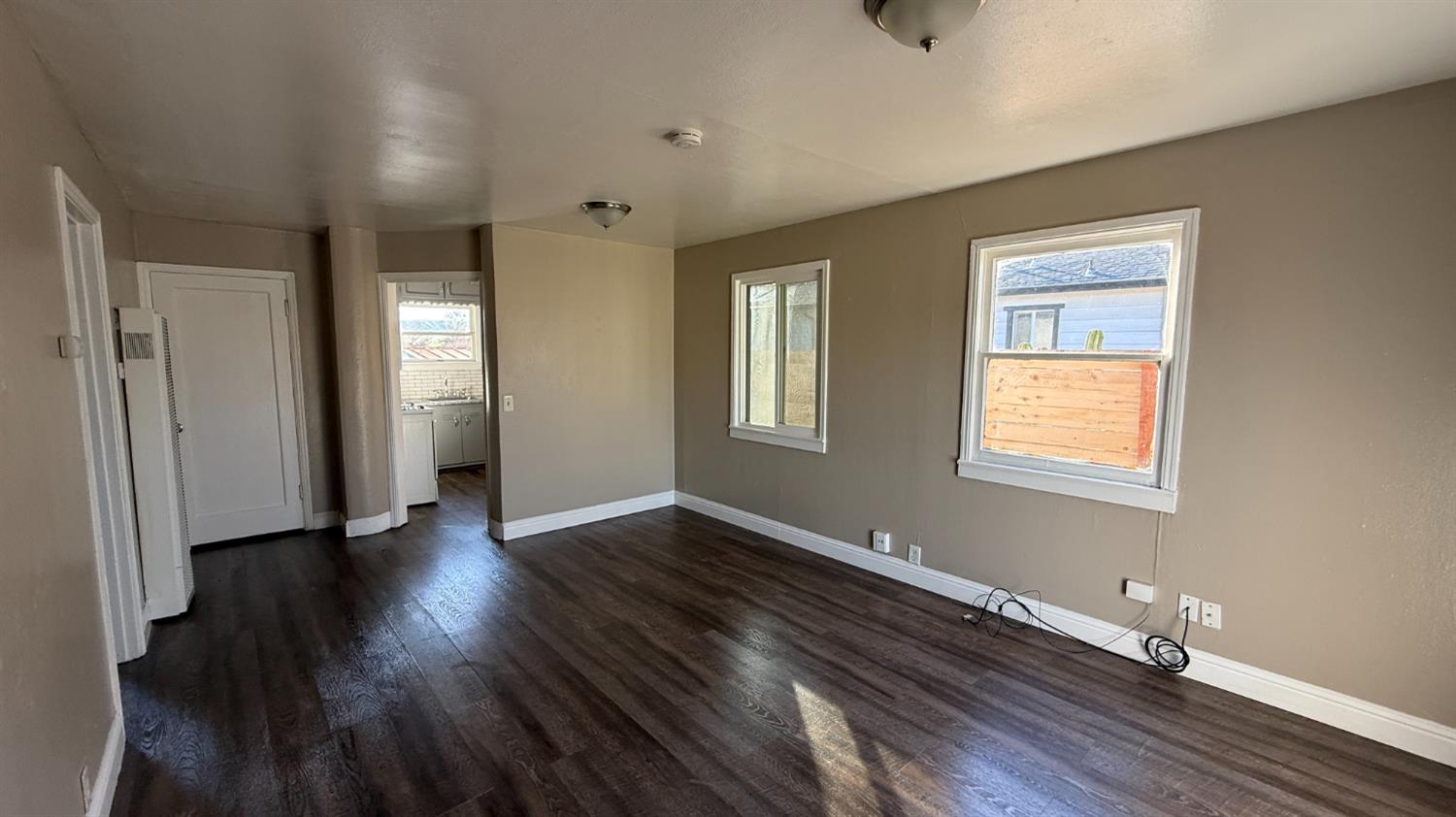 720 East Pleasant Street Coalinga, CA 93210 - Photo 7 of 18 a view of an empty room with wooden floor and a window