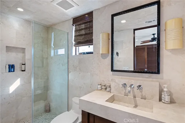 a bathroom with a sink a toilet and shower