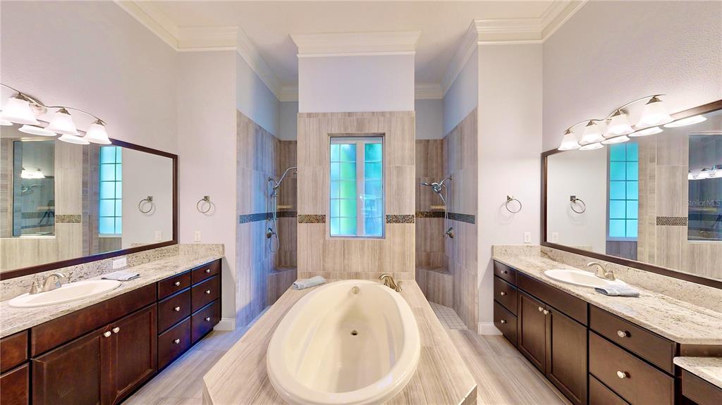 6219 Tiroco Way Windermere, FL 34786 - Photo 12 of 72 a spacious bathroom with a double vanity sink a large mirror a shower and a bathtub