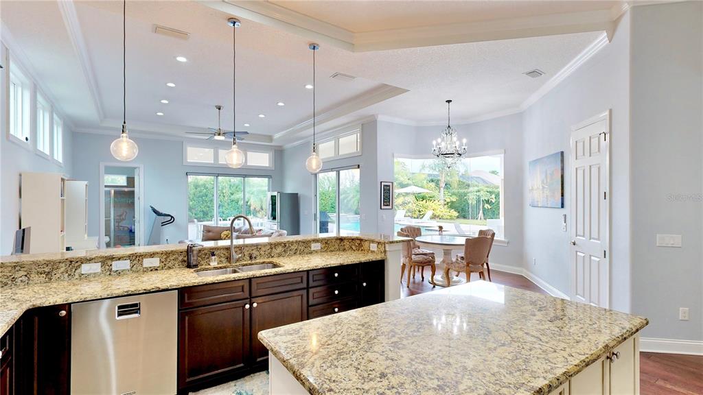 6219 Tiroco Way Windermere, FL 34786 - Photo 38 of 72 a kitchen with a stove a sink dishwasher a dining table and chairs with wooden floor