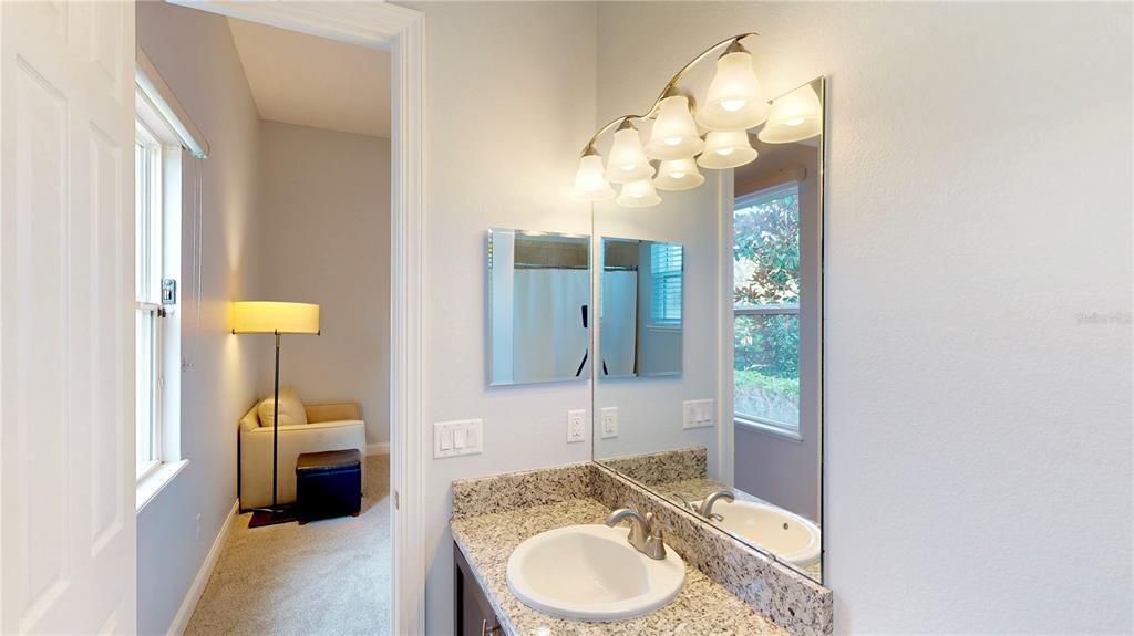 6219 Tiroco Way Windermere, FL 34786 - Photo 50 of 72 a en suite bathroom with a granite countertop sink and a mirror