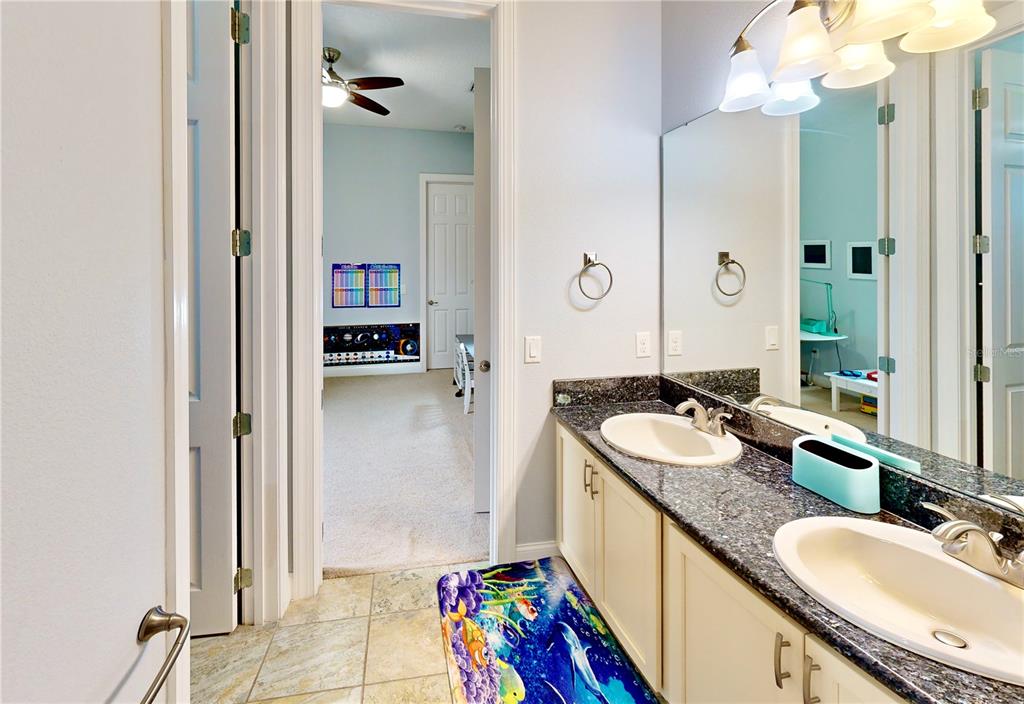 6219 Tiroco Way Windermere, FL 34786 - Photo 60 of 72 a bathroom with a granite countertop double vanity sink a mirror and a shower