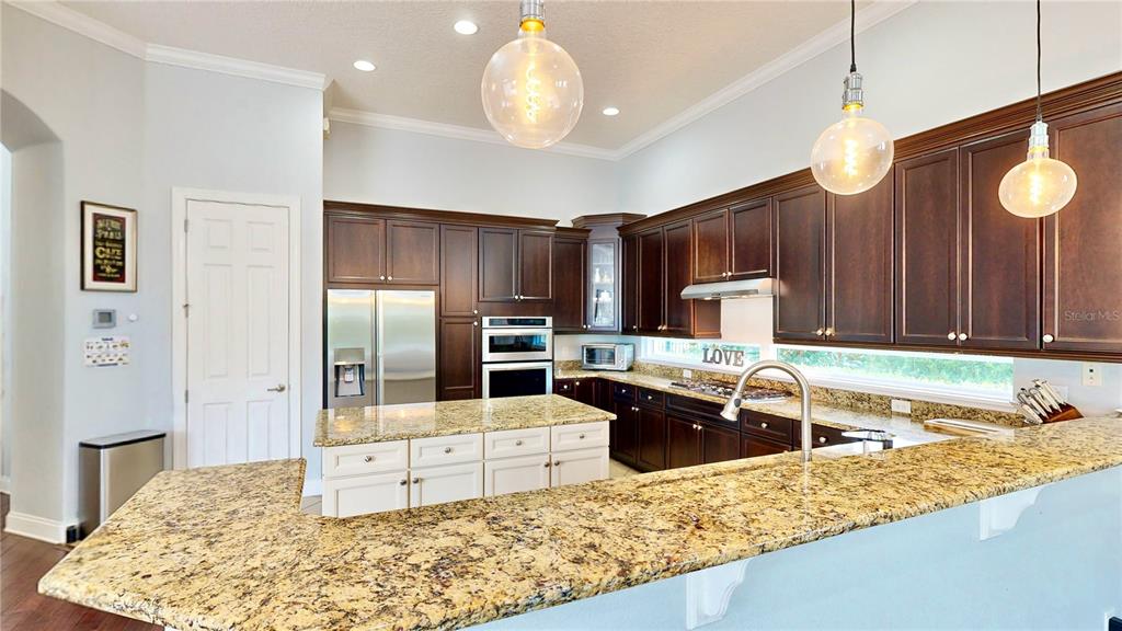 6219 Tiroco Way Windermere, FL 34786 - Photo 7 of 72 a kitchen with stainless steel appliances granite countertop a sink refrigerator and cabinets