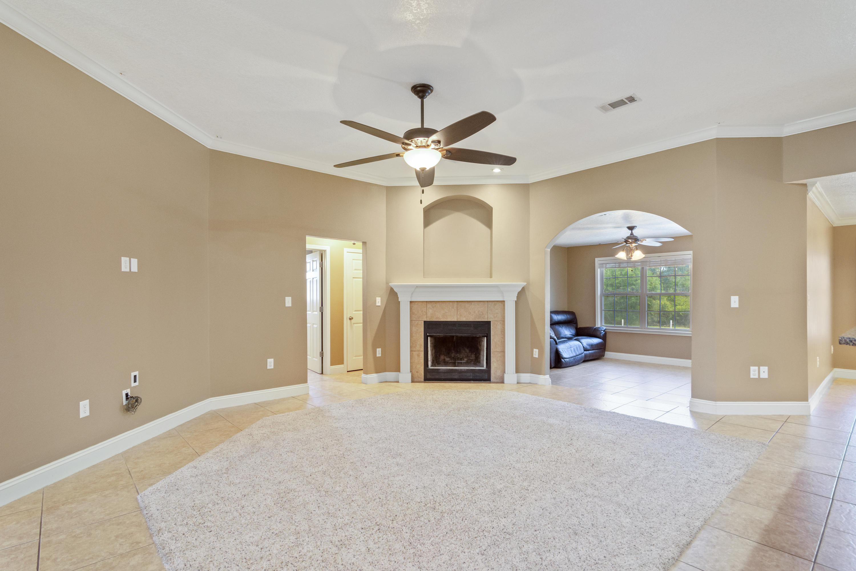 6589 Old River Road Baker, FL 32531 - Photo 12 of 49 a view of a livingroom with a fireplace and a chandelier fan