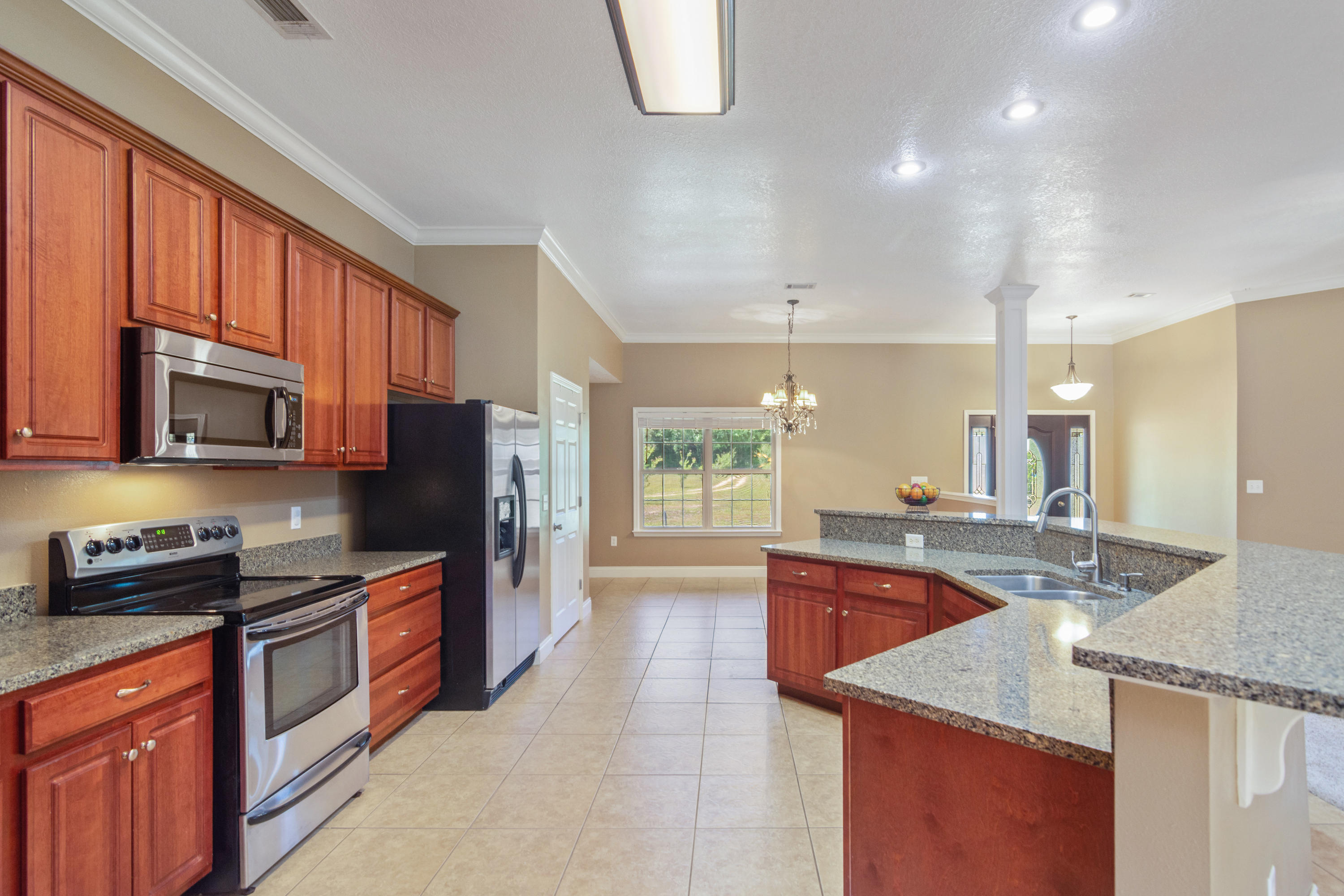 6589 Old River Road Baker, FL 32531 - Photo 19 of 49 a kitchen with stainless steel appliances granite countertop a sink stove and refrigerator