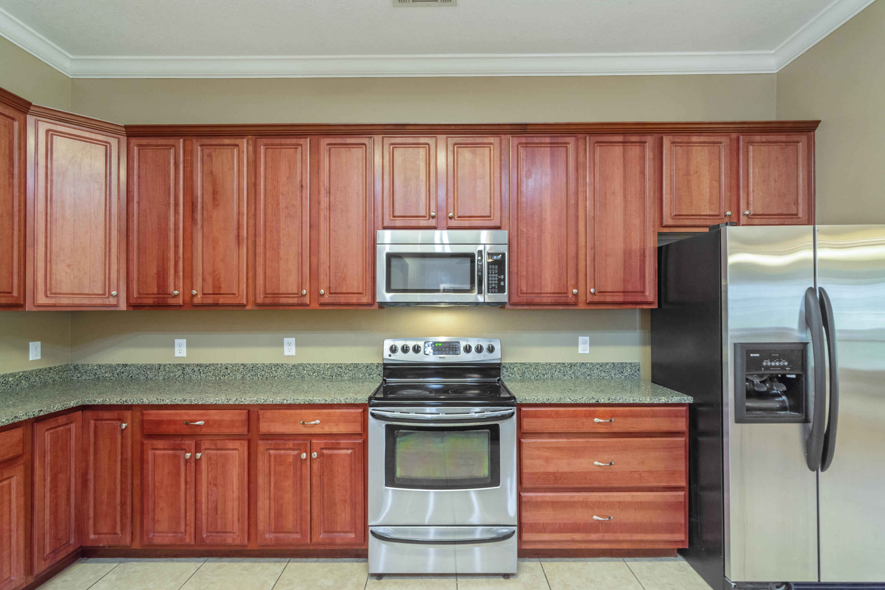 6589 Old River Road Baker, FL 32531 - Photo 20 of 49 a kitchen with granite countertop wooden cabinets and stainless steel appliances