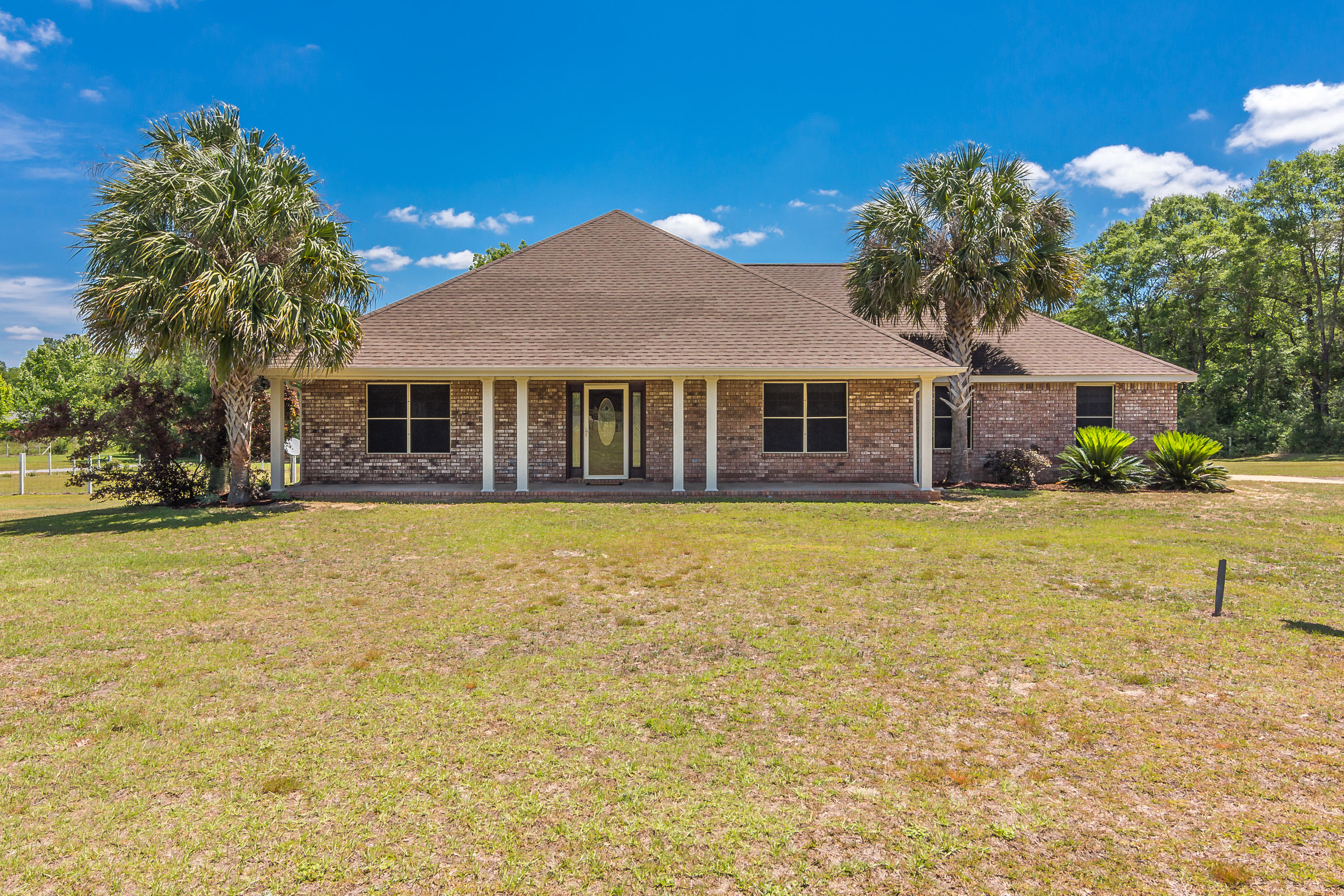 6589 Old River Road Baker, FL 32531 - Photo 2 of 49 a front view of a house with a garden