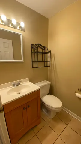 a bathroom with a toilet sink vanity and mirror