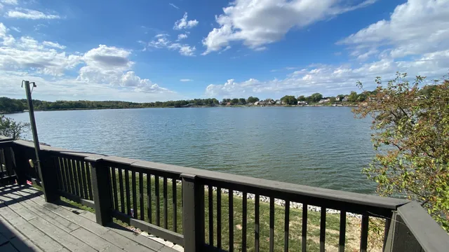 a balcony with wooden floor and lake view
