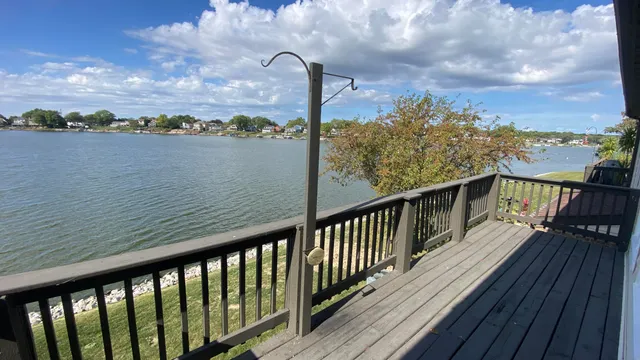a view of a balcony with wooden floor next to a lake