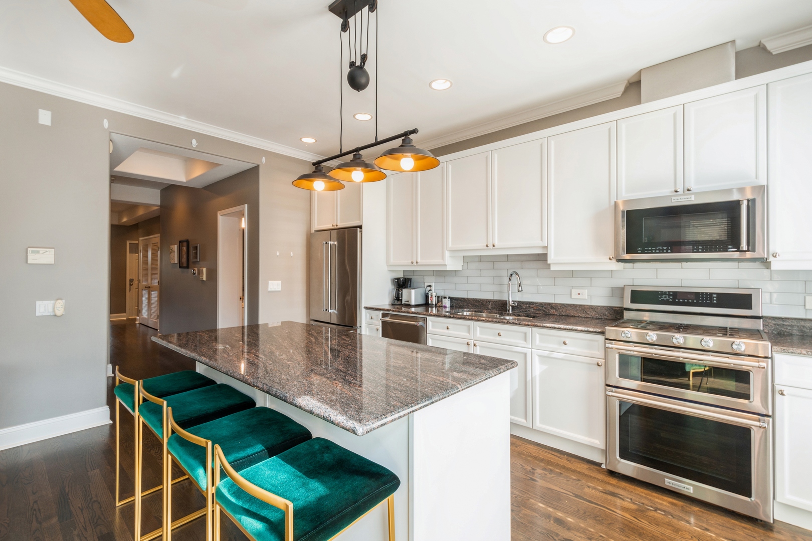 1355 North Mohawk Street, Unit 3S Chicago, IL 60610 - Photo 4 of 18 a kitchen with kitchen island granite countertop a stove a sink and a microwave