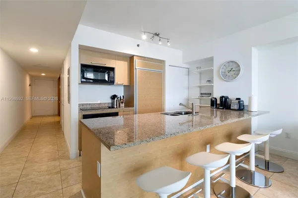 a large kitchen with kitchen island a table and chairs in it